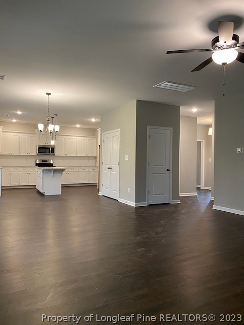 411 B & B Loop Road Raeford, NC 28376 - Photo 13 of 47 an empty room with wooden floor kitchen view and a refrigerator