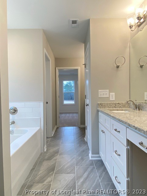 411 B & B Loop Road Raeford, NC 28376 - Photo 34 of 47 a spacious bathroom with a granite countertop sink a mirror and a bathtub