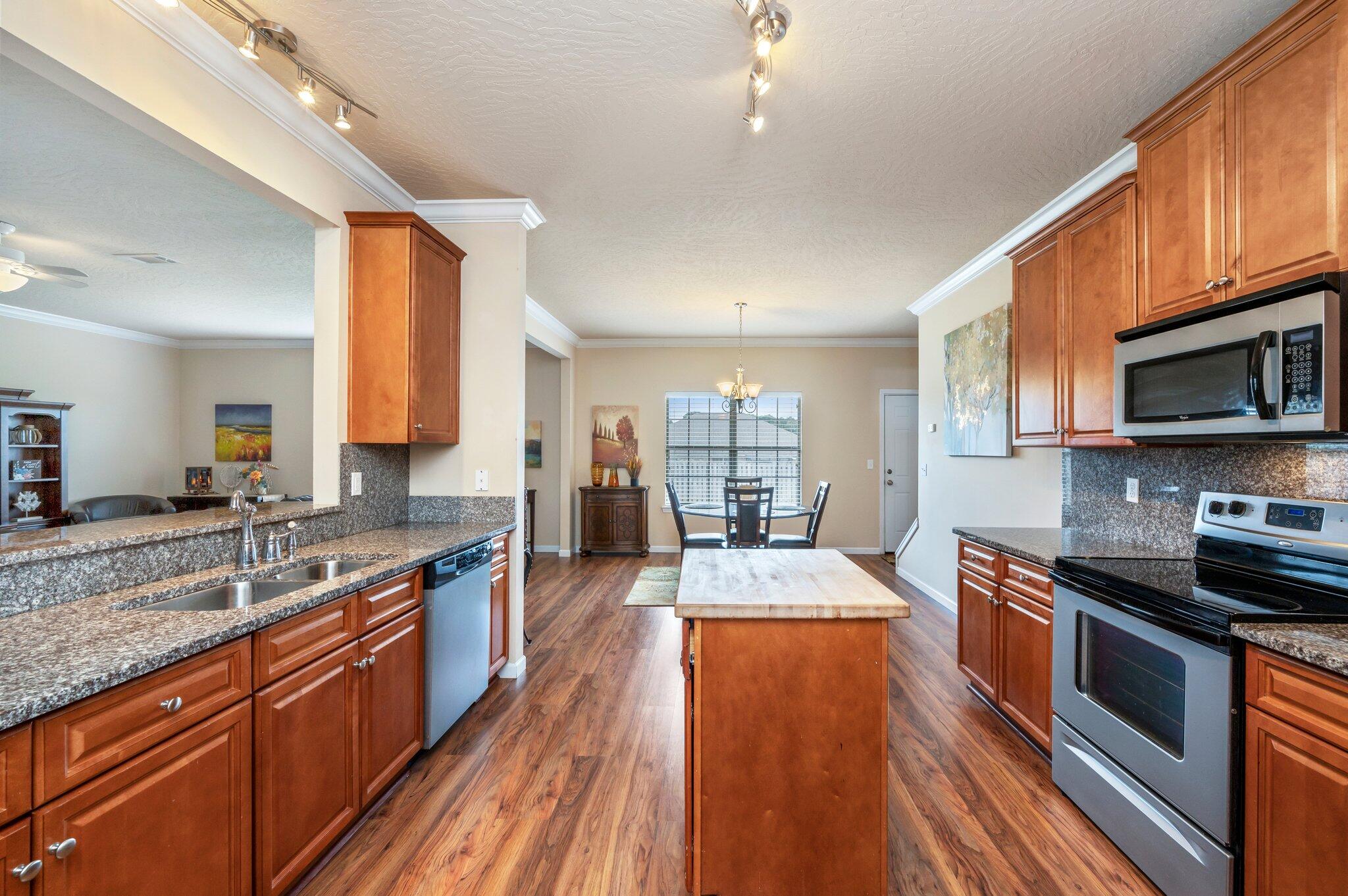 5231 Moore Loop Crestview, FL 32536 - Photo 12 of 45 a large kitchen with stainless steel appliances granite countertop a lot of counter space and wooden floors