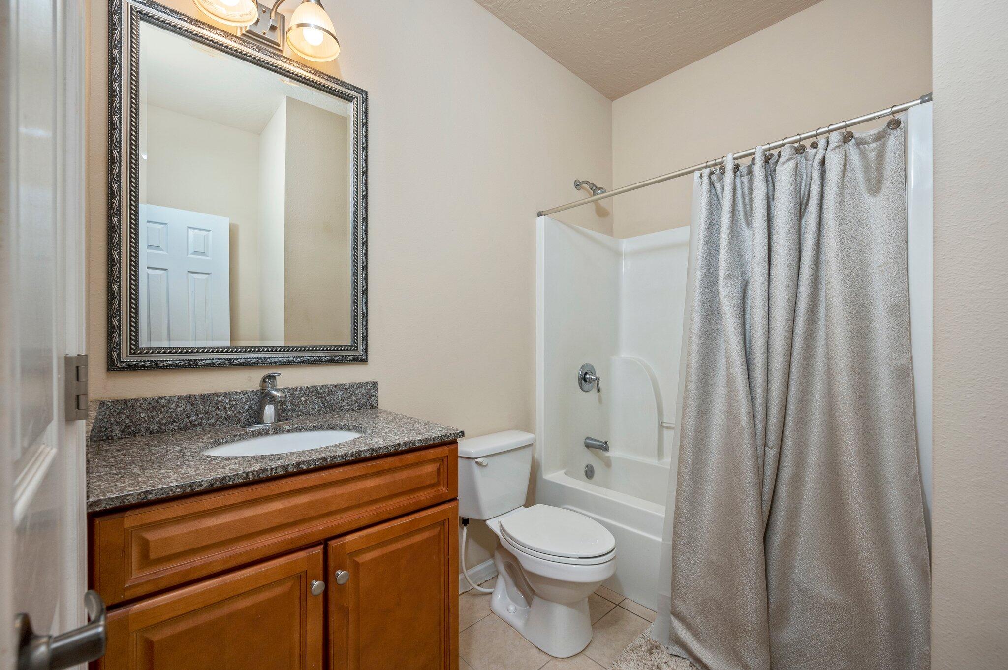 5231 Moore Loop Crestview, FL 32536 - Photo 34 of 45 a bathroom with a granite countertop sink toilet and shower