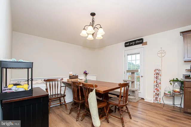 a view of a dining room with furniture a chandelier and wooden floor