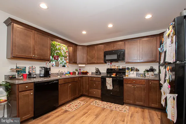a kitchen with stainless steel appliances granite countertop wooden cabinets sink and a granite counter top