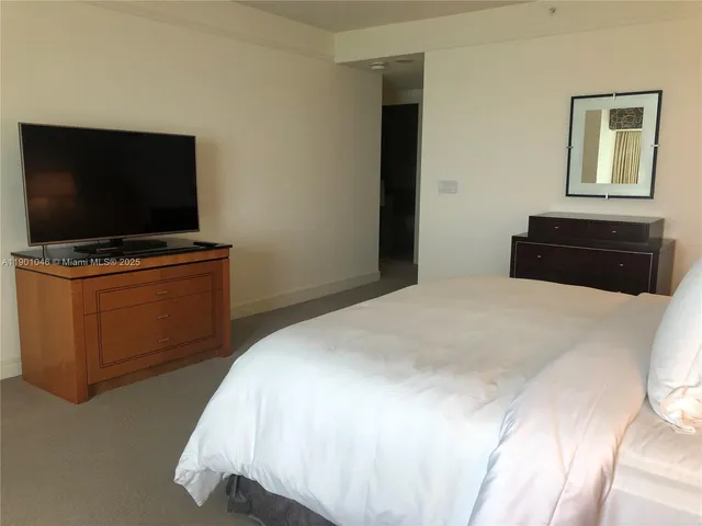 a bedroom with a bed and lamp on dresser