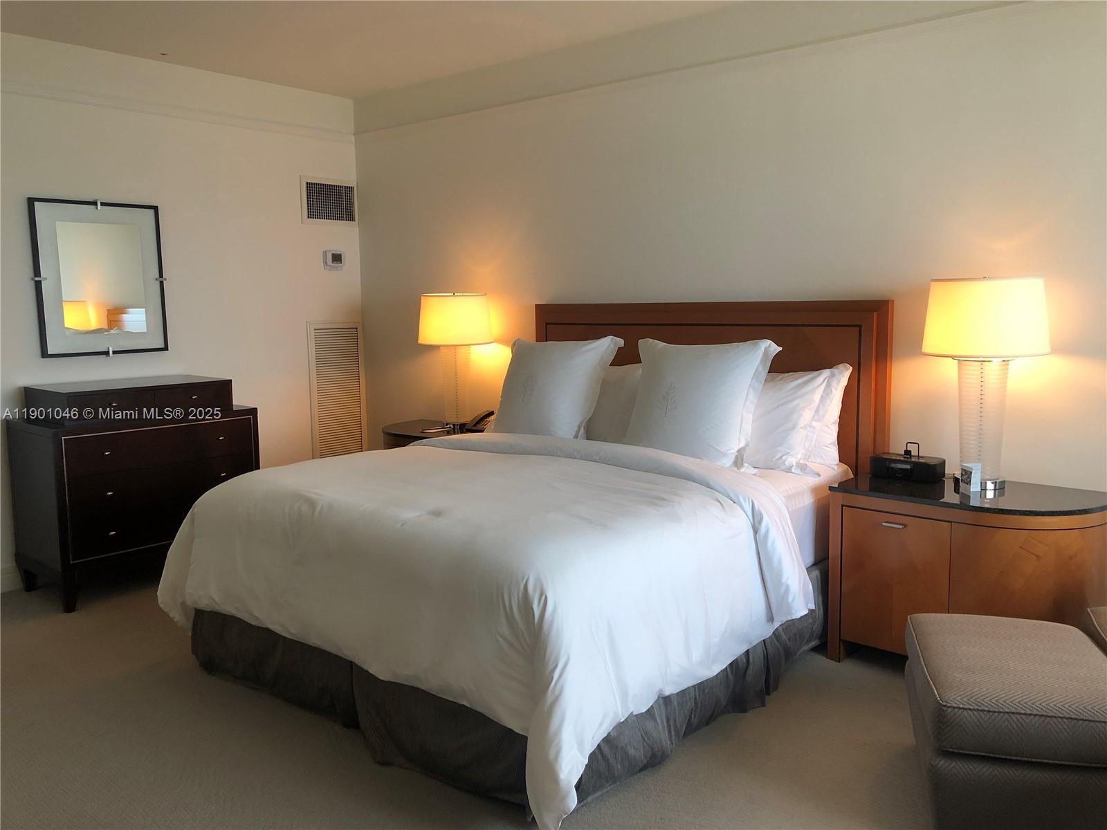 1435 Brickell Avenue, Unit 3506 Miami, FL 33131 - Photo 15 of 32 a bedroom with a bed and lamp on dresser