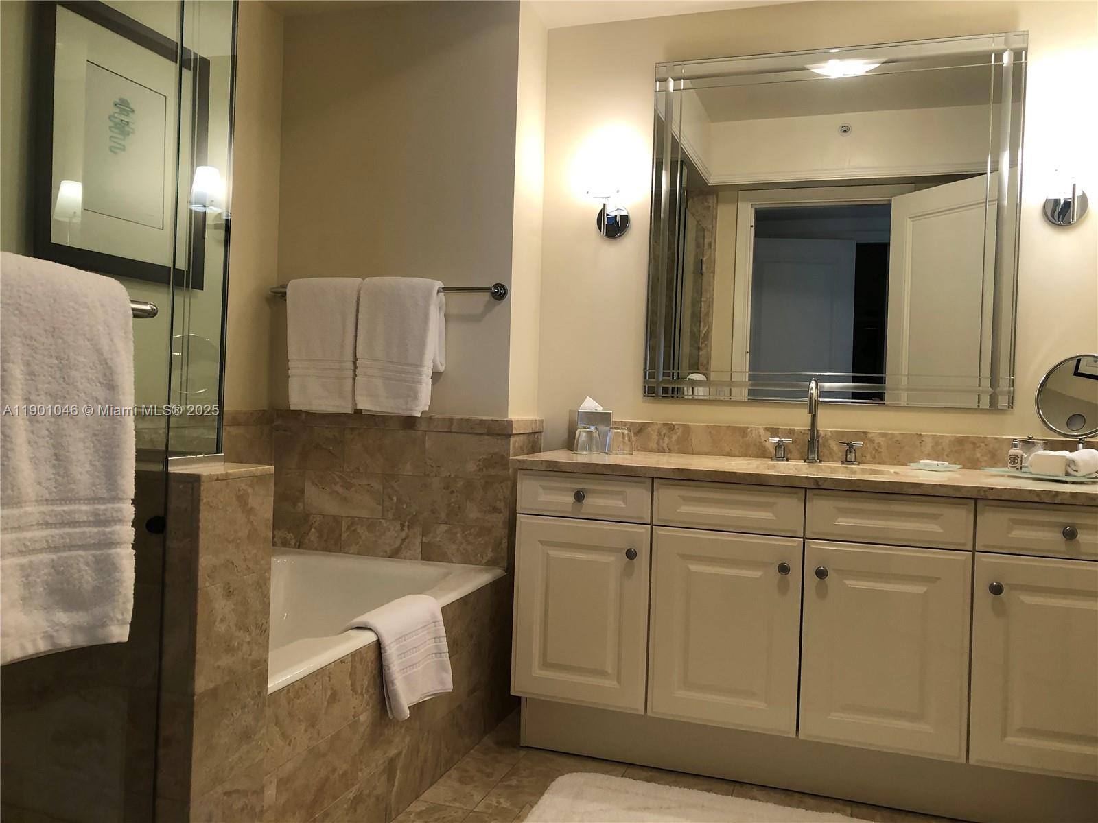 1435 Brickell Avenue, Unit 3506 Miami, FL 33131 - Photo 17 of 32 a bathroom with a sink and a mirror