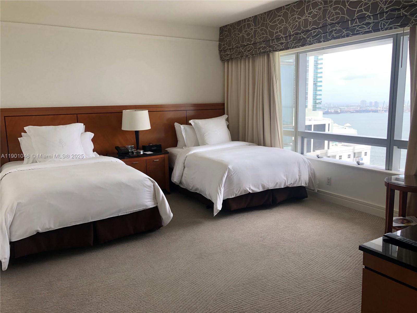 1435 Brickell Avenue, Unit 3506 Miami, FL 33131 - Photo 19 of 32 a spacious bedroom with two beds and a large window