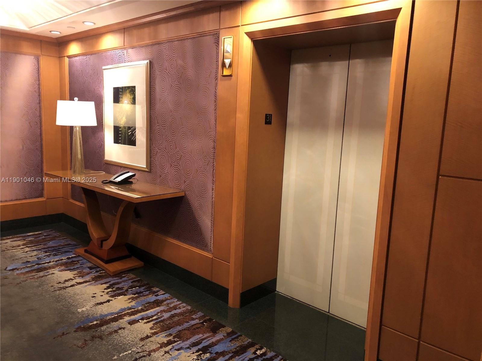 1435 Brickell Avenue, Unit 3506 Miami, FL 33131 - Photo 24 of 32 a view of a hallway with wooden floor and a cabinet