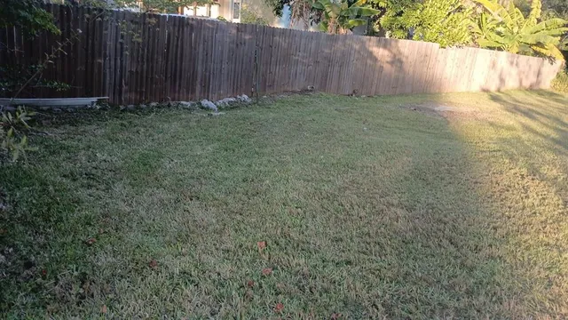 a view of backyard with wooden fence