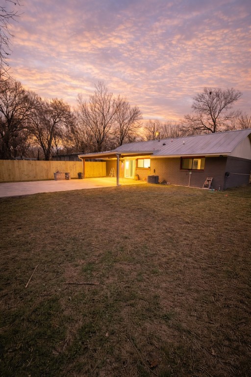 2014 Pecan Street Bastrop, TX 78602 - Photo 13 of 13 Back of house with driveway, a carport, a patio area, and a metal roof