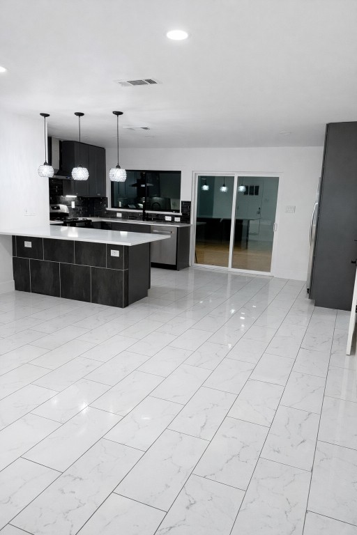 2014 Pecan Street Bastrop, TX 78602 - Photo 5 of 13 Kitchen with a peninsula, hanging light fixtures, dark cabinets, and modern cabinets
