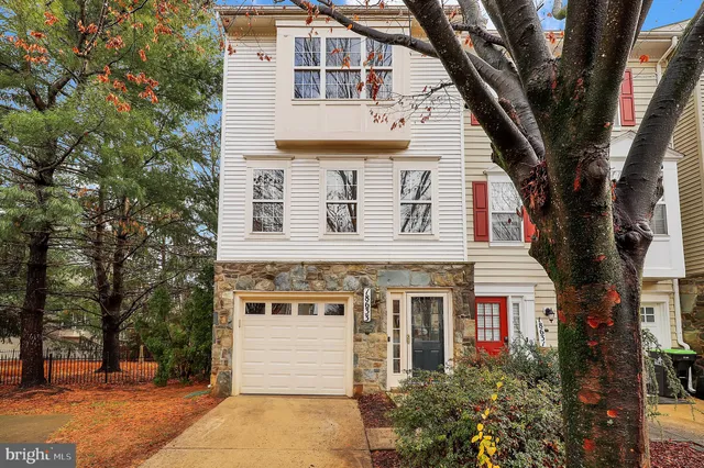 a front view of a house with a tree