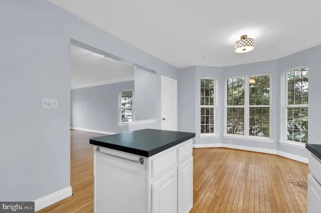 a kitchen with a wooden floor and a large window