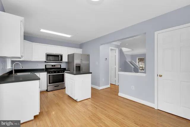 a kitchen with stainless steel appliances a refrigerator and a stove top oven