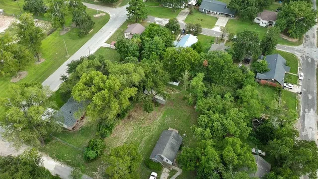 an aerial view of residential house with outdoor space and trees all around