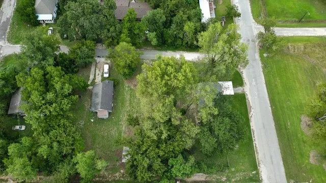 an aerial view of residential houses with outdoor space and trees
