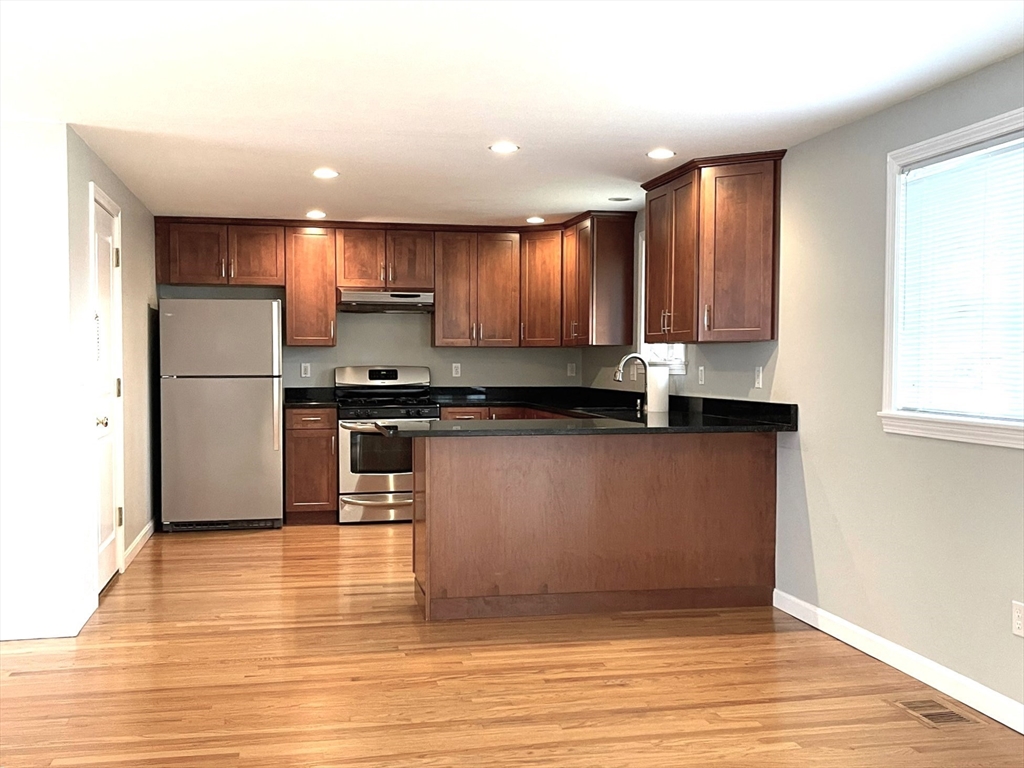 2 McAdams Road Framingham, MA 01701 - Photo 3 of 17 a kitchen with stainless steel appliances granite countertop a refrigerator a sink and a stove