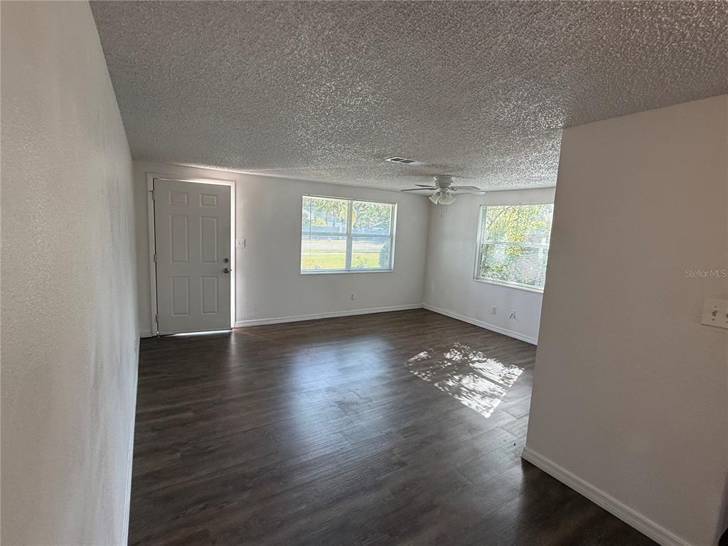 5320 South Lockwood Ridge Road Sarasota, FL 34231 - Photo 6 of 29 an empty room with wooden floor and windows