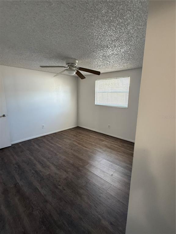 5320 South Lockwood Ridge Road Sarasota, FL 34231 - Photo 10 of 29 an empty room with a wooden floor and windows