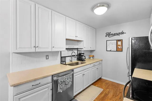 a kitchen with stainless steel appliances a stove top oven a refrigerator a kitchen island with a sink and cabinets