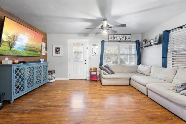 a living room with furniture a flat screen tv and a large window