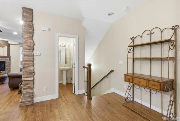 a view of a hallway with wooden floor and staircase