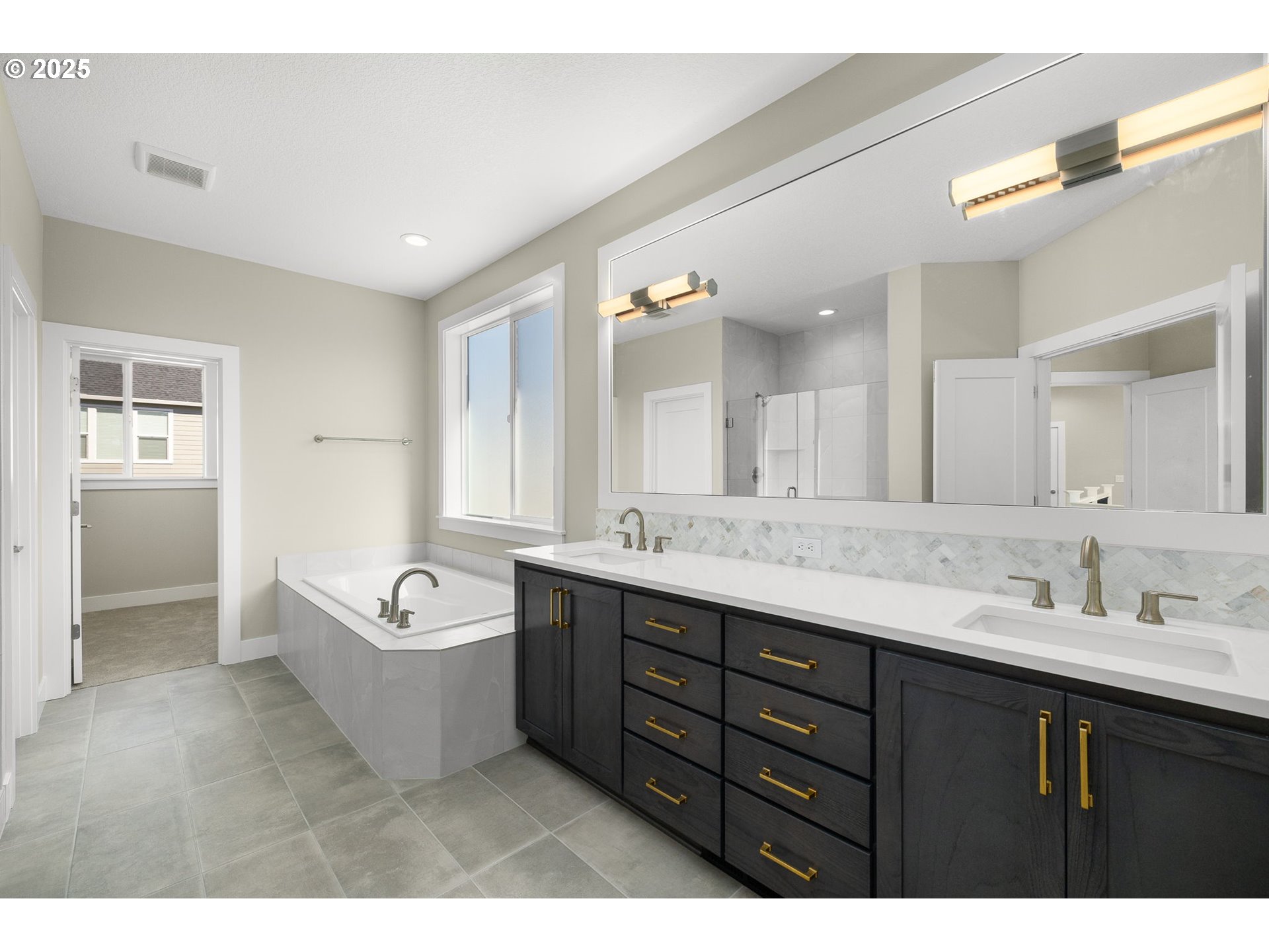 17839 Northwest Layla Drive, Unit LOT 12 Portland, OR 97229 - Photo 26 of 44 a spacious bathroom with a tub sink double vanity granite tub shower and mirror