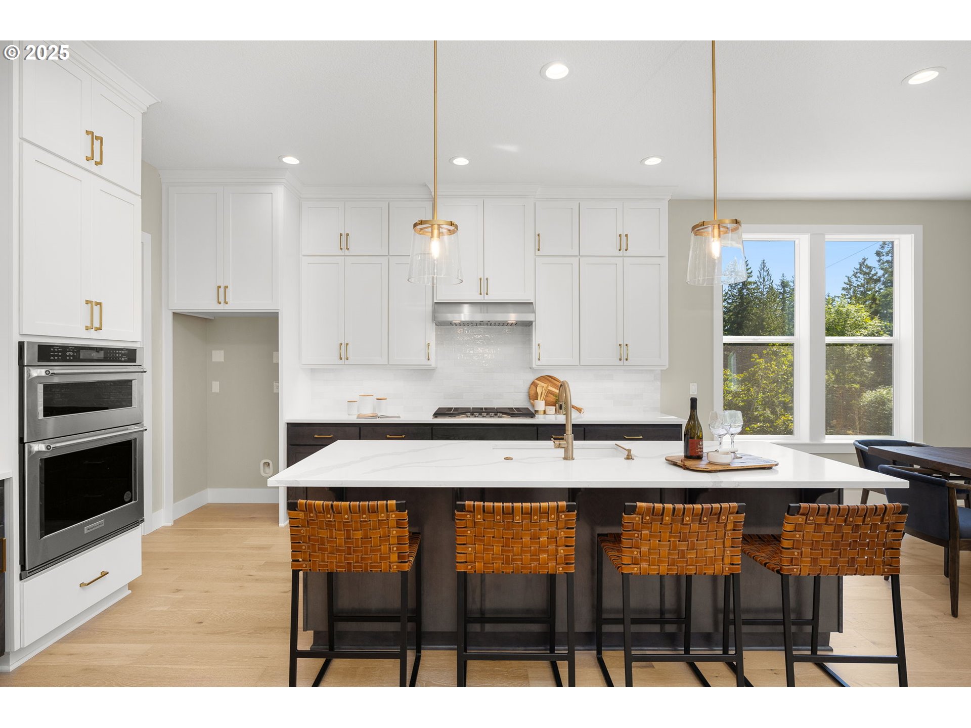 17839 Northwest Layla Drive, Unit LOT 12 Portland, OR 97229 - Photo 9 of 44 a kitchen with stainless steel appliances kitchen island granite countertop a table chairs sink and cabinets