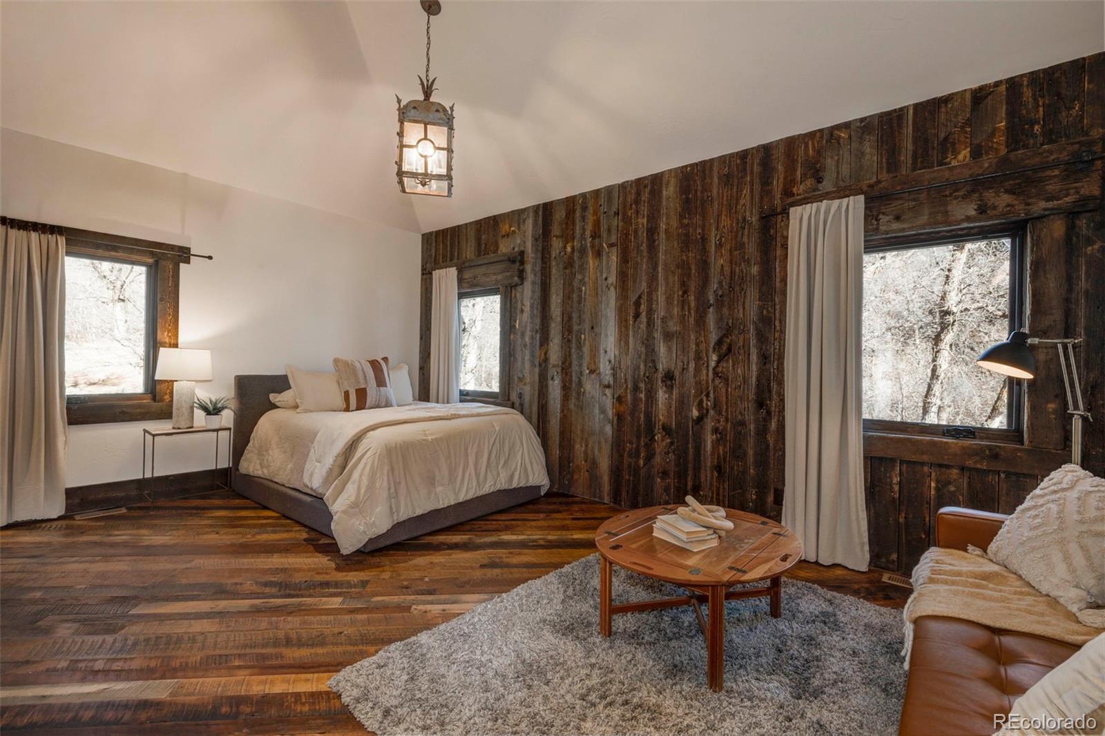 3755 North Rampart Range Road Littleton, CO 80125 - Photo 37 of 50 a bedroom with a bed a table and chair