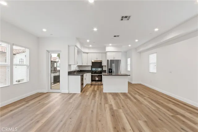 a view of kitchen with stainless steel appliances refrigerator stove microwave and cabinets
