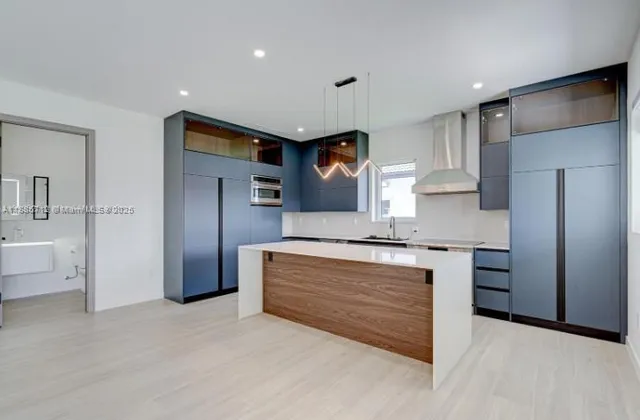 a kitchen with stainless steel appliances granite countertop a stove a sink and a refrigerator