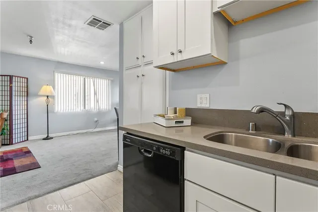 a kitchen with stainless steel appliances granite countertop a sink and a white cabinets
