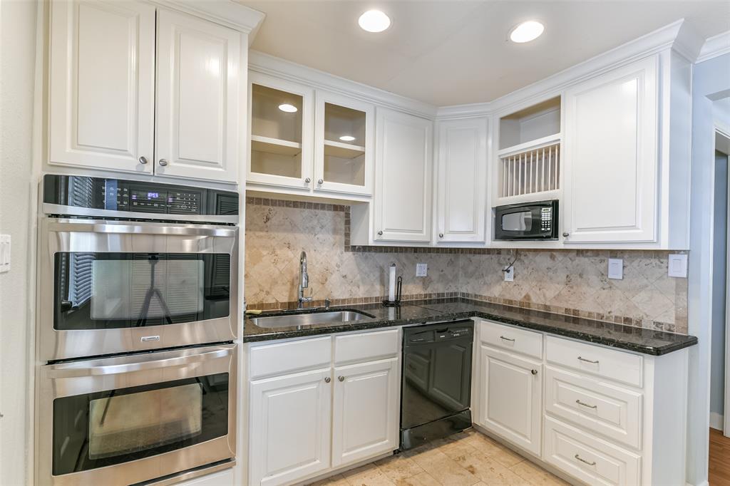 a kitchen with granite countertop white cabinets stainless steel appliances and sink