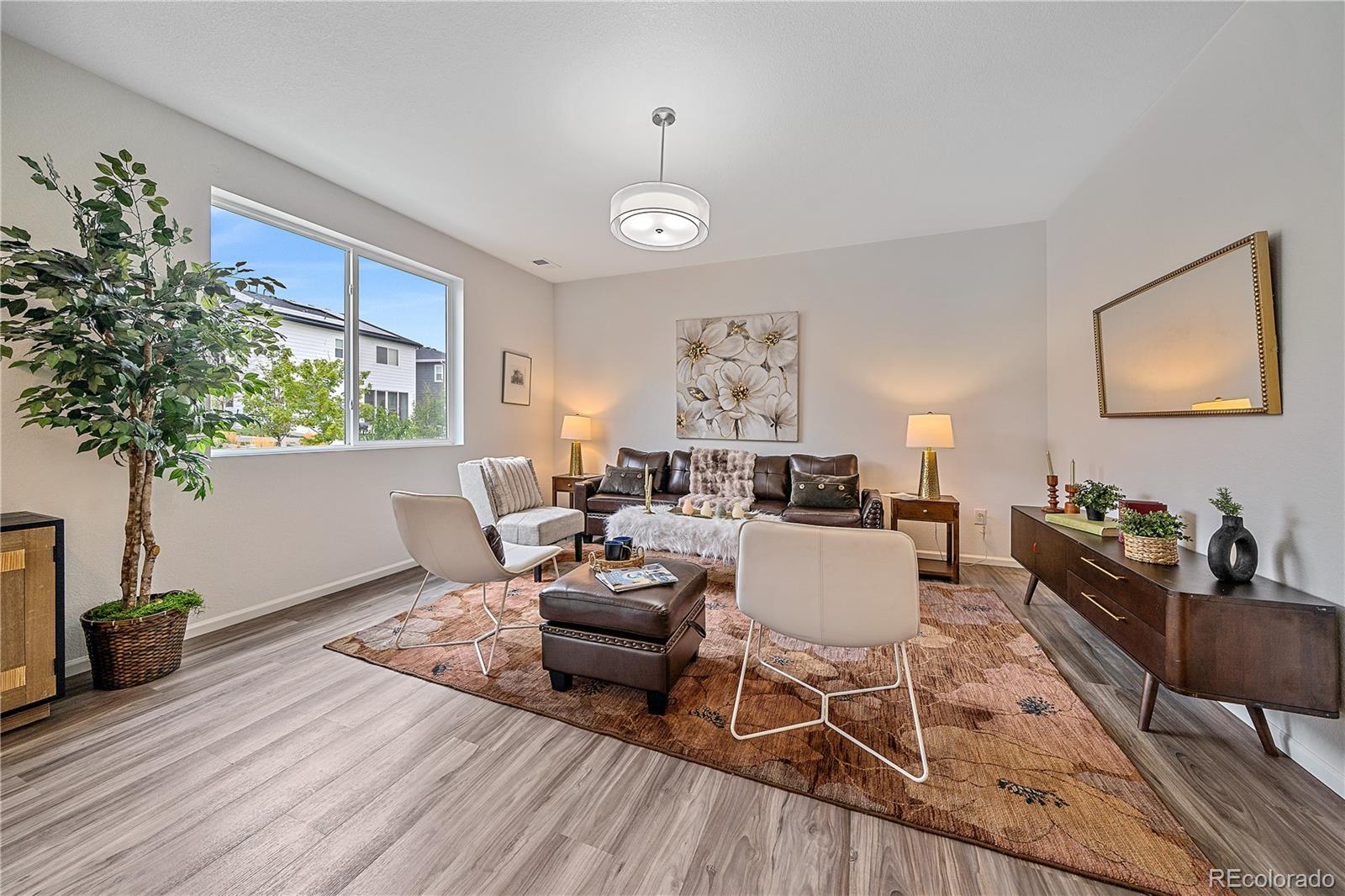 5465 Gray Wolf Lane Castle Rock, CO 80104 - Photo 7 of 21 a living room with furniture a dining table with wooden floor and potted plants