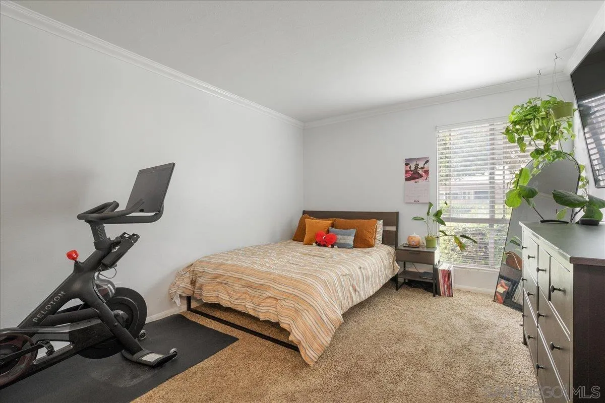 3579 Ruffin Road, Unit 105 San Diego, CA 92123 - Photo 11 of 23 a bedroom with a bed gym equipment and a flat screen tv