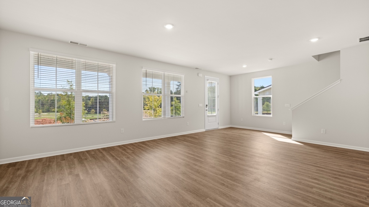 918 Stow Lane Monroe, GA 30655 - Photo 16 of 43 an empty room with wooden floor and windows