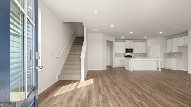 a kitchen with stainless steel appliances cabinets a sink and wooden floor