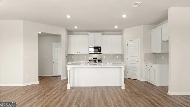 a kitchen with sink a microwave and cabinets