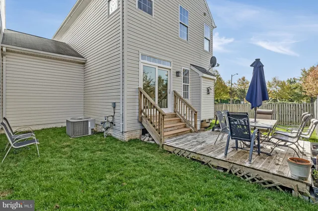 a view of a chair and table in backyard of the house