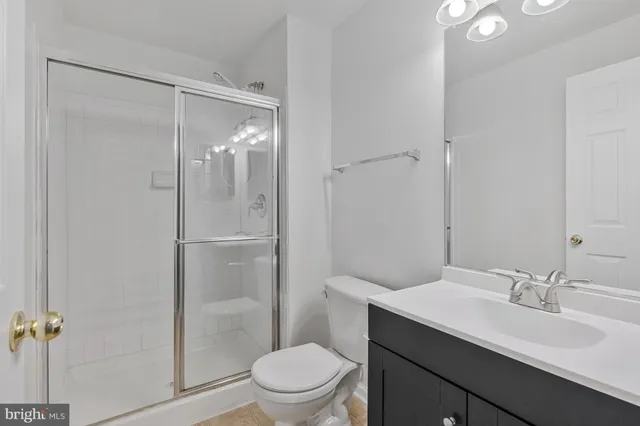 a bathroom with a shower sink vanity mirror and toilet