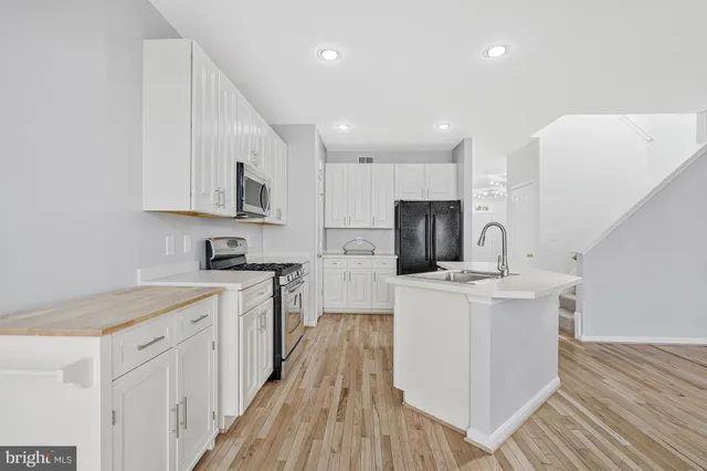 a kitchen with cabinets and wooden floor