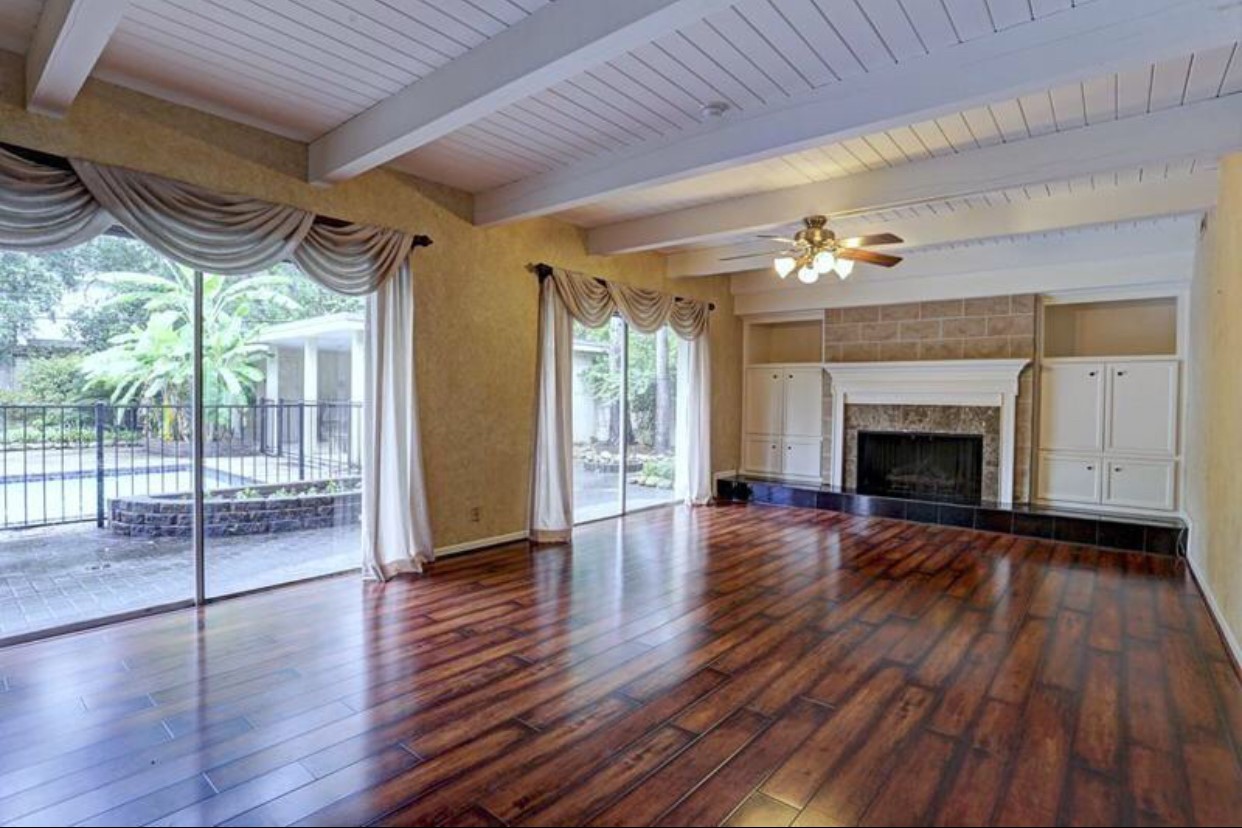 11910 Steppingstone Lane Houston, TX 77024 - Photo 4 of 14 a view of empty room with wooden floor and fireplace