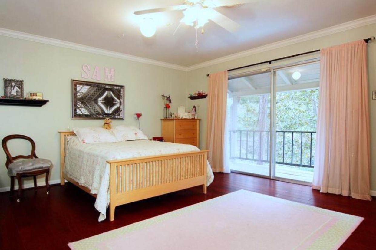 11910 Steppingstone Lane Houston, TX 77024 - Photo 9 of 14 a bedroom with a bed and a large window