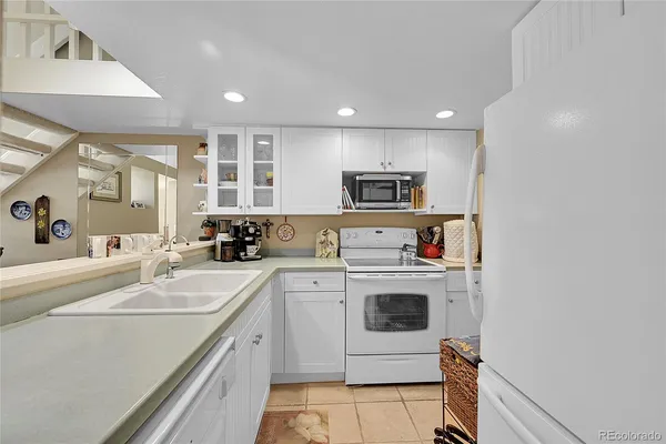 a kitchen with a sink a stove and white cabinets
