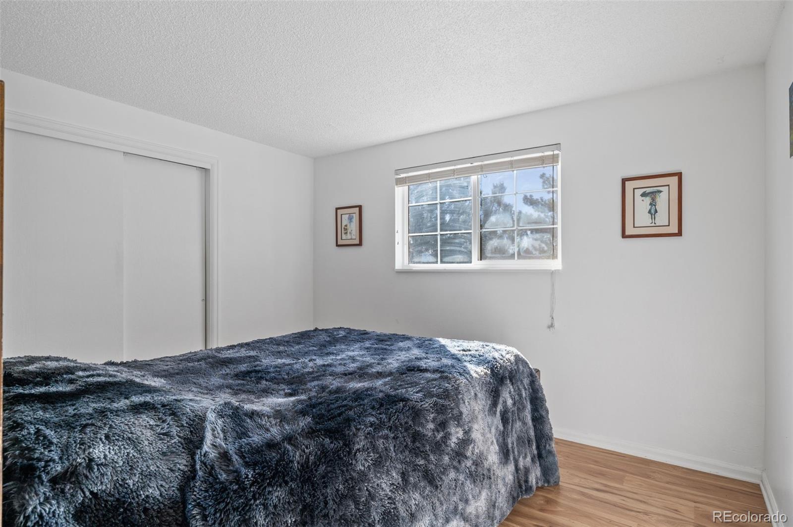 357 Saturn Place Lone Tree, CO 80124 - Photo 15 of 39 a bedroom with a bed and wooden floor
