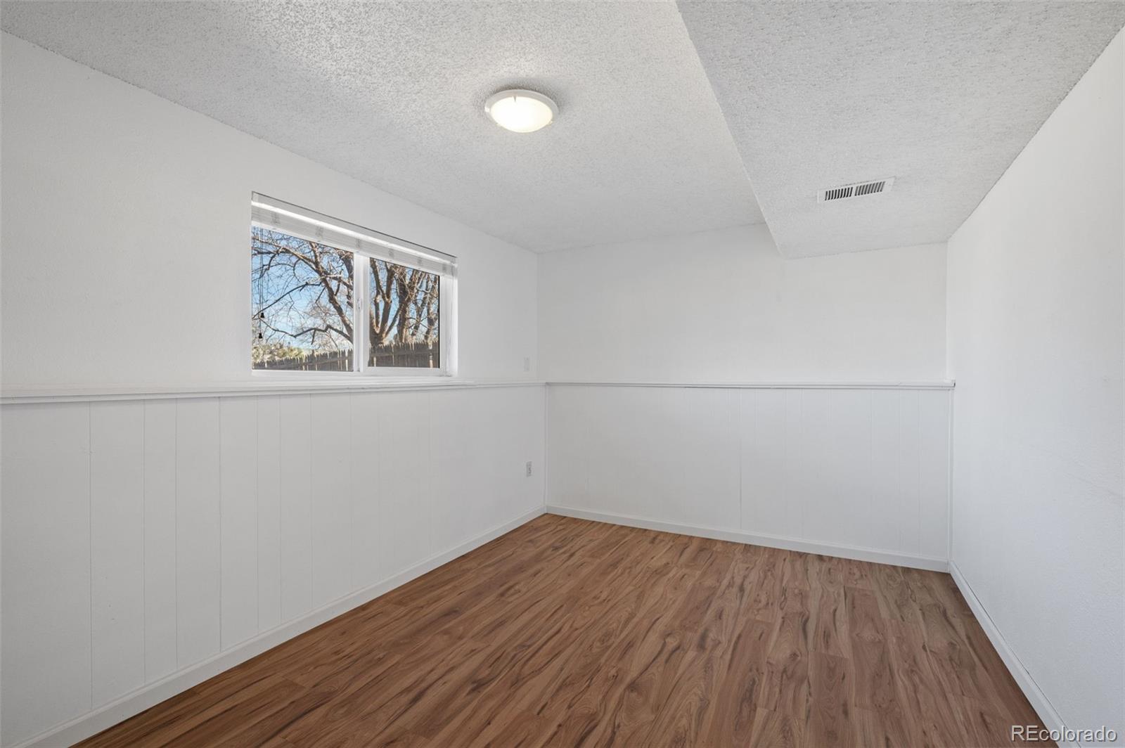 357 Saturn Place Lone Tree, CO 80124 - Photo 20 of 39 an empty room with a window and wooden floor