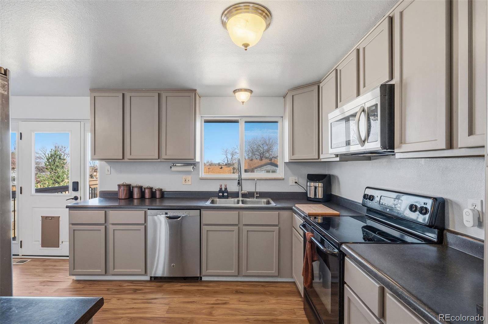 357 Saturn Place Lone Tree, CO 80124 - Photo 2 of 39 a kitchen with stainless steel appliances granite countertop a sink stove and cabinets