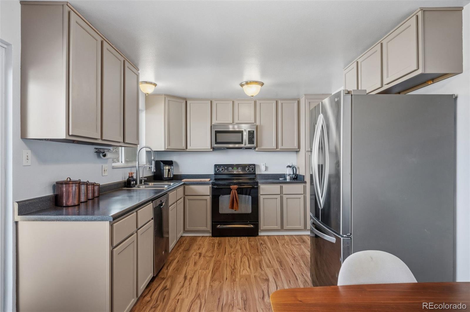 357 Saturn Place Lone Tree, CO 80124 - Photo 6 of 39 a kitchen with stainless steel appliances granite countertop a refrigerator a stove top oven a sink and dishwasher