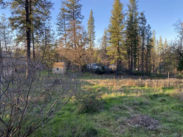 a view of a backyard with table and chairs and a fire pit