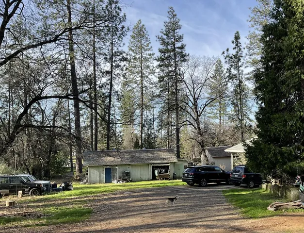 a view of residential houses with yard and trees