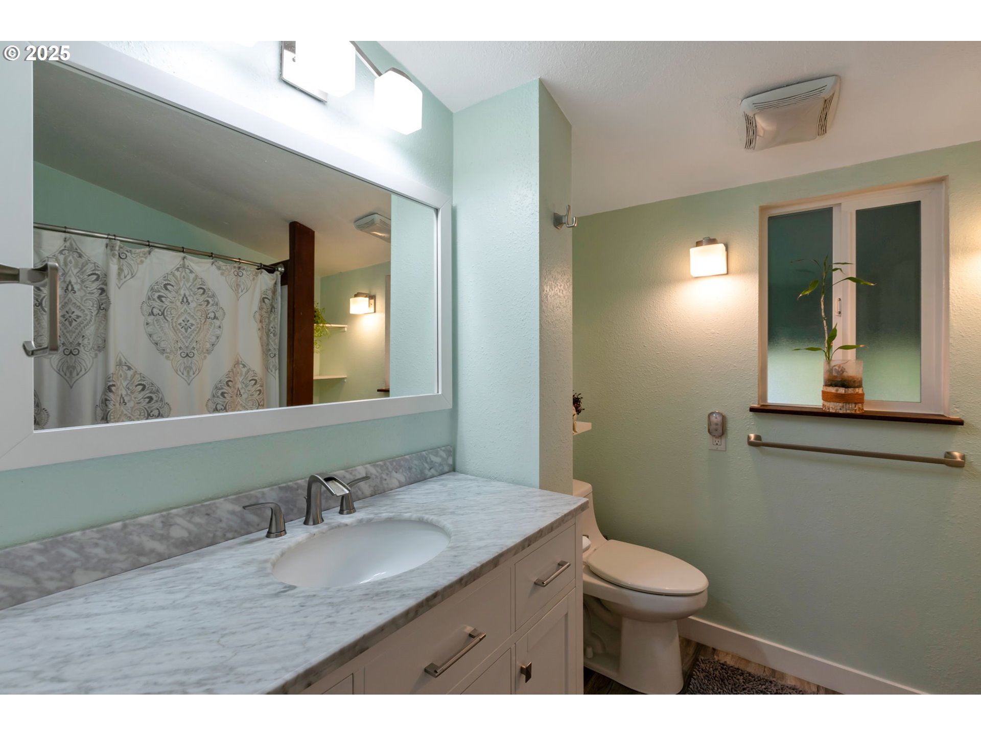 9224 Southwest 26th Avenue Portland, OR 97219 - Photo 12 of 30 a bathroom with a granite countertop sink toilet and mirror